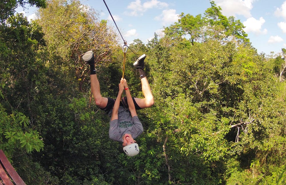 Men hanging in fun Tulum Ziplines